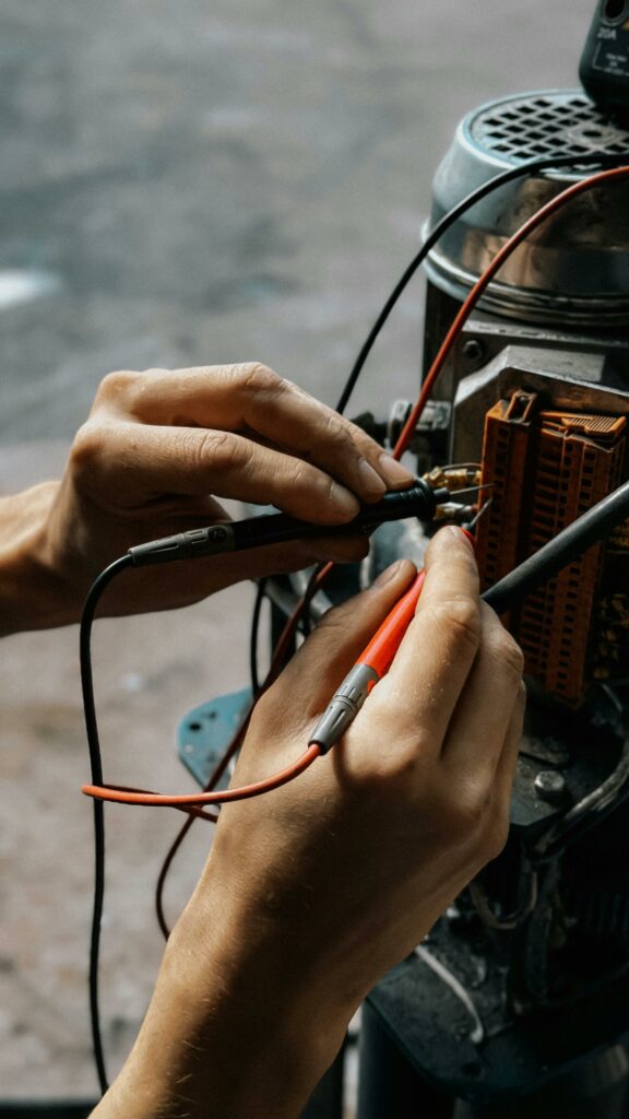 Close-up of hands using multimeter on motor wires. Precision in electrical testing.